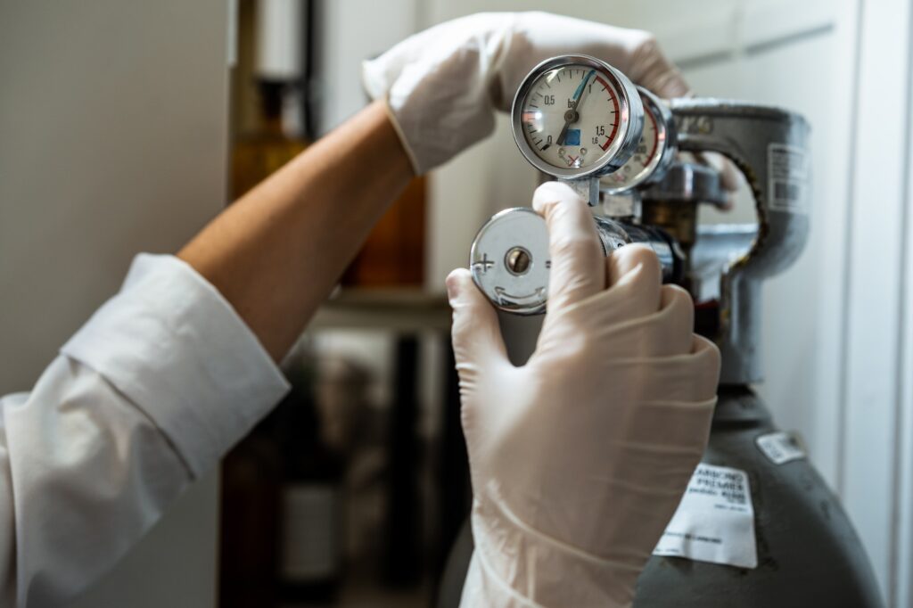Close up of the hands of a technician in gloves adjusting a barometer of compressed air